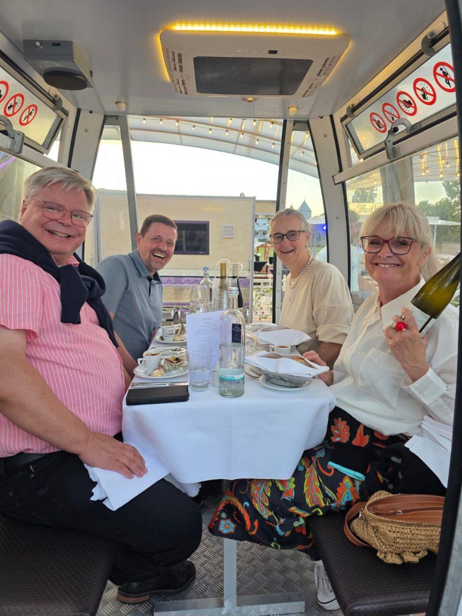 Gäste beim gemeinsamen Dinner in einer Riesenradgondel über Usedom