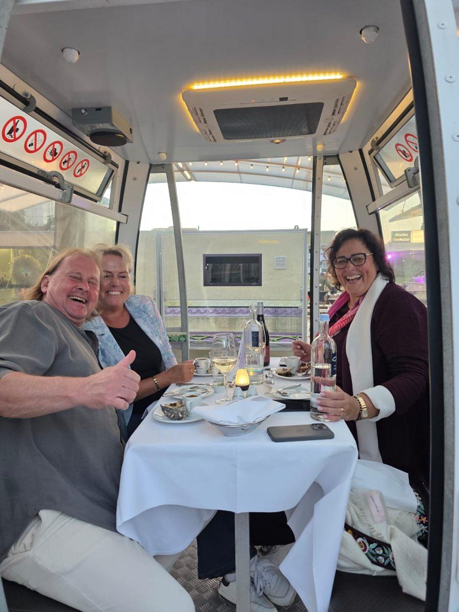 Gut gelaunte Gäste beim Riesenrad Dinner 2026 in einer Gondel auf Usedom