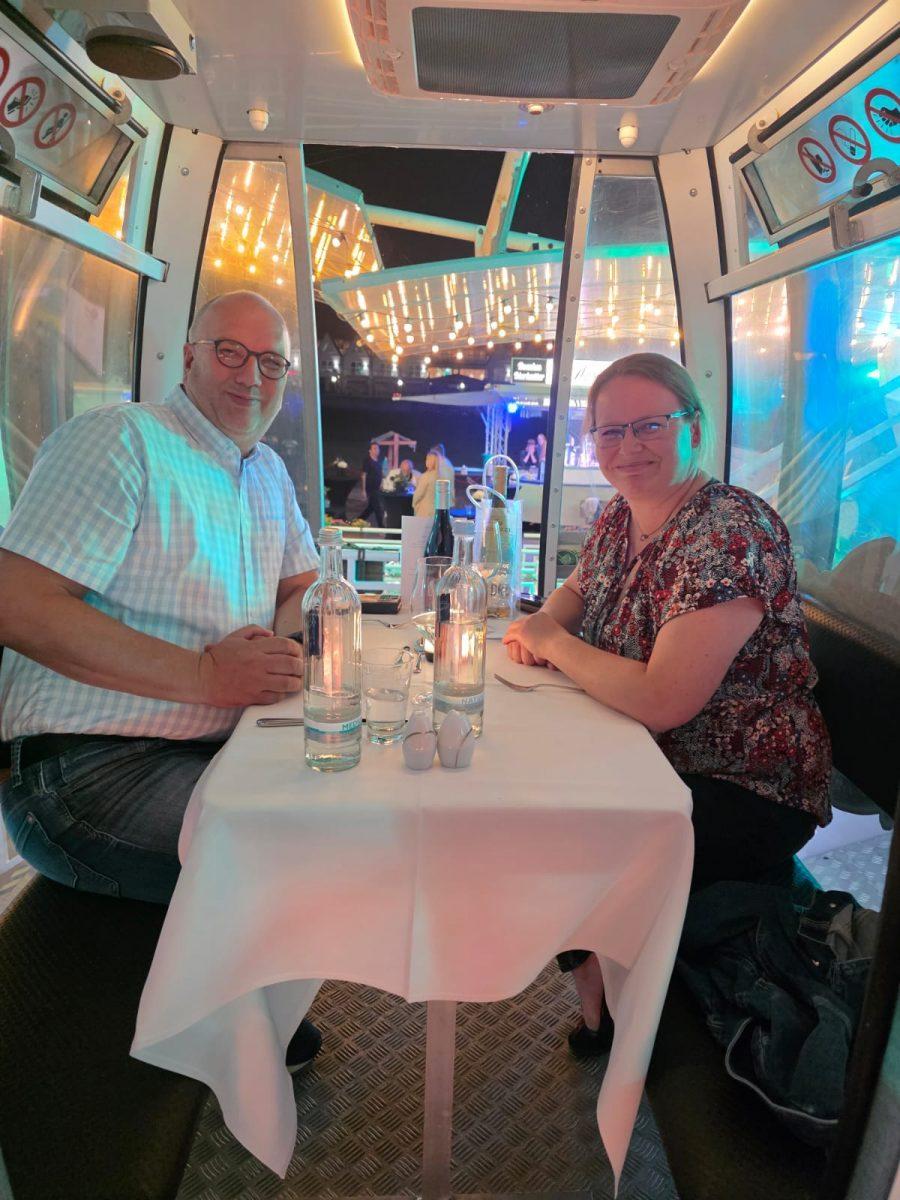 Gäste beim Riesenrad Dinner 2026 in einer farbig beleuchteten Gondel