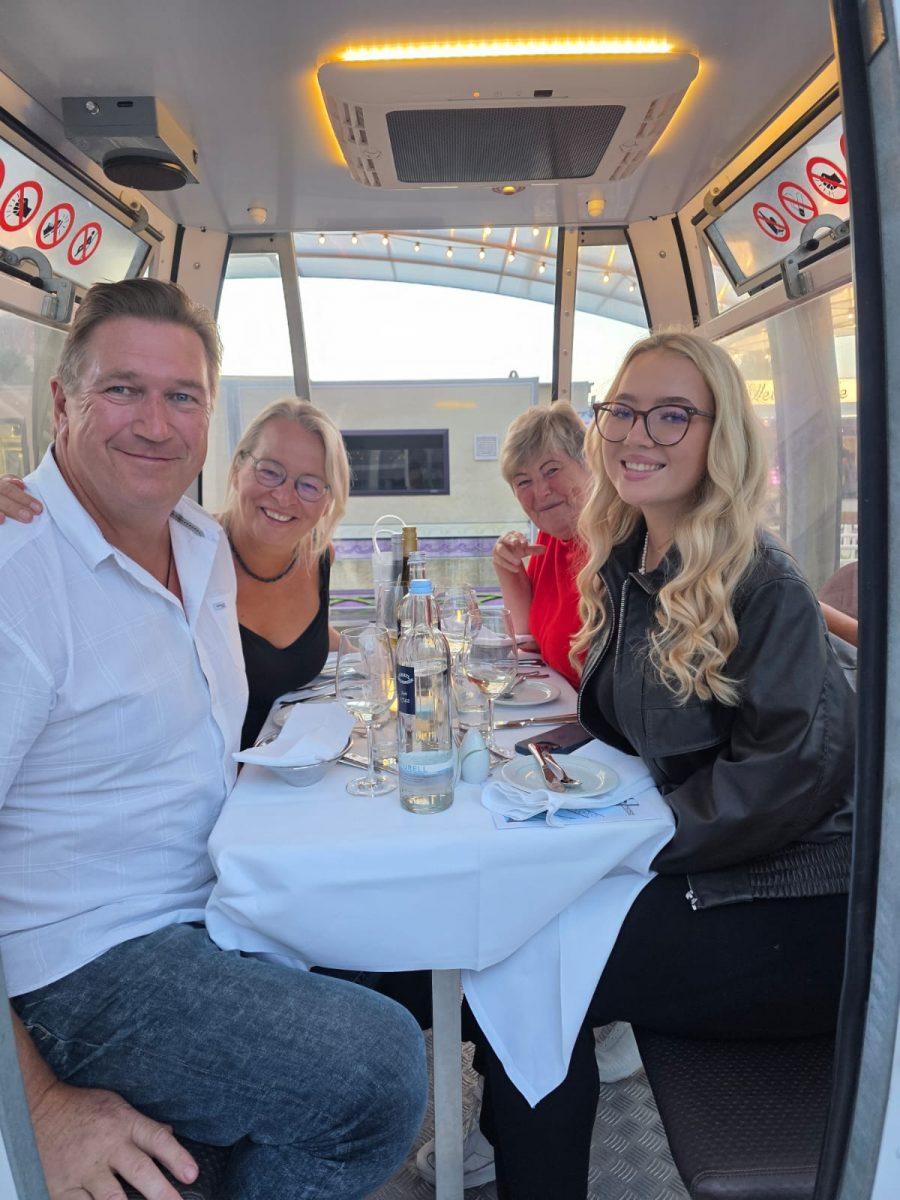 Gäste an einem gedeckten Tisch in einer Riesenradgondel beim Dinner auf Usedom
