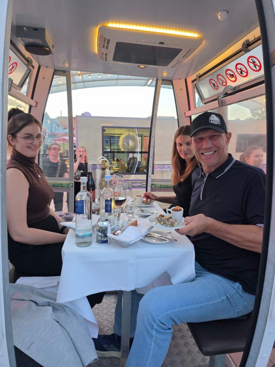 Gäste stoßen beim Riesenrad Dinner 2026 in einer Gondel auf Usedom an